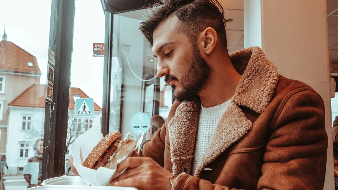 Gjest som spiser hamburger hos Emil's